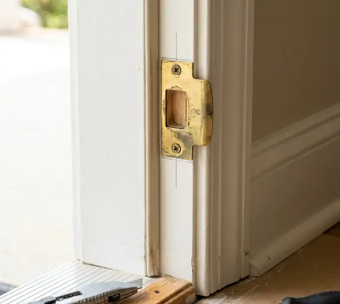 Strike plate being aligned in a door jamb during a WowFix repair in Pineville