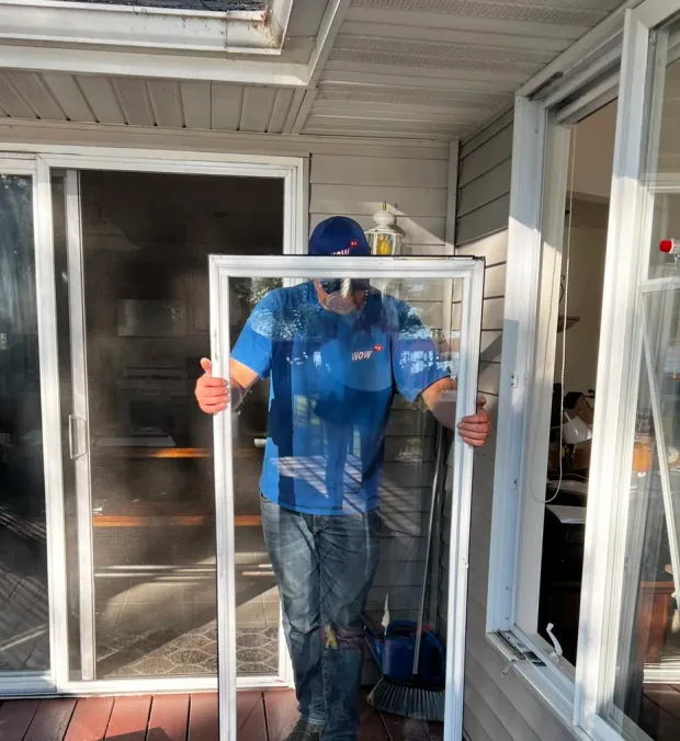 WowFix master carrying a freshly glazed unit to the opening — made to measure, ready to install