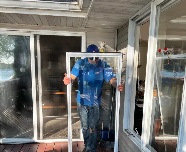 WowFix master carrying a freshly glazed unit to the opening — made to measure, ready to install
