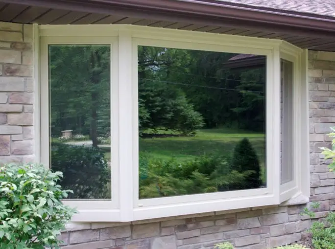Bow window on a stone home — set true to the view