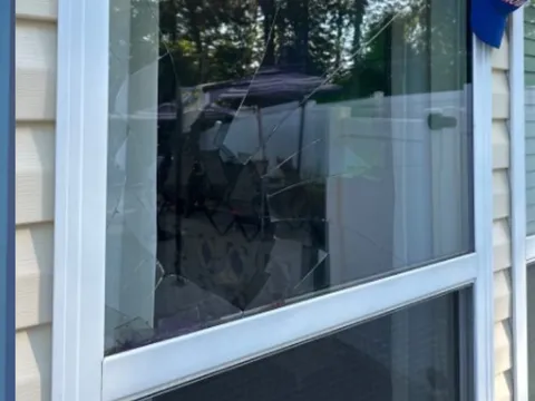 Shattered upper pane on a white double-hung window before WowFix installed made-to-measure glass