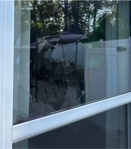Shattered upper pane on a white double-hung window before WowFix built and installed a made-to-measure replacement glass unit