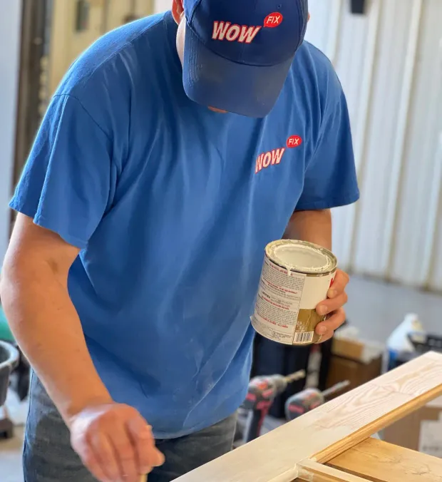 WowFix craftsman priming a fabricated window repair piece before installation