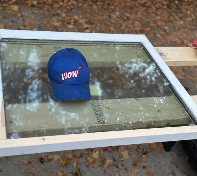 Cracked sash glass laid out on sawhorses ahead of a made-to-measure WowFix replacement in Alpharetta