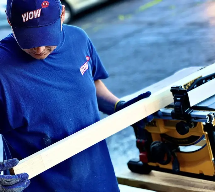WowFix craftsman carrying milled lumber for a wood rebuild