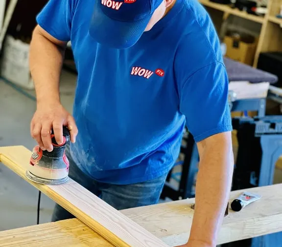 WowFix craftsman sanding a milled replacement piece to its final profile for a Sandy Springs repair