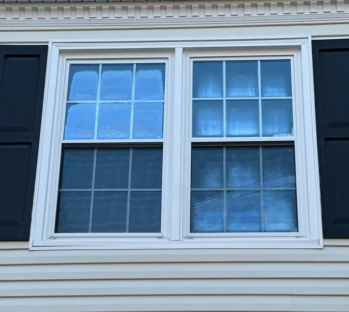Quality double-hung windows against blue shutters after replacement