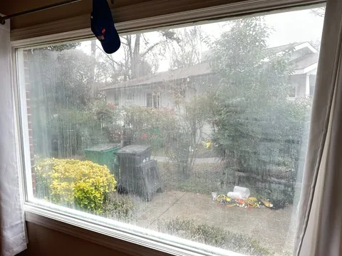 Failed-seal picture window streaked with trapped condensation before a WowFix glass-only swap