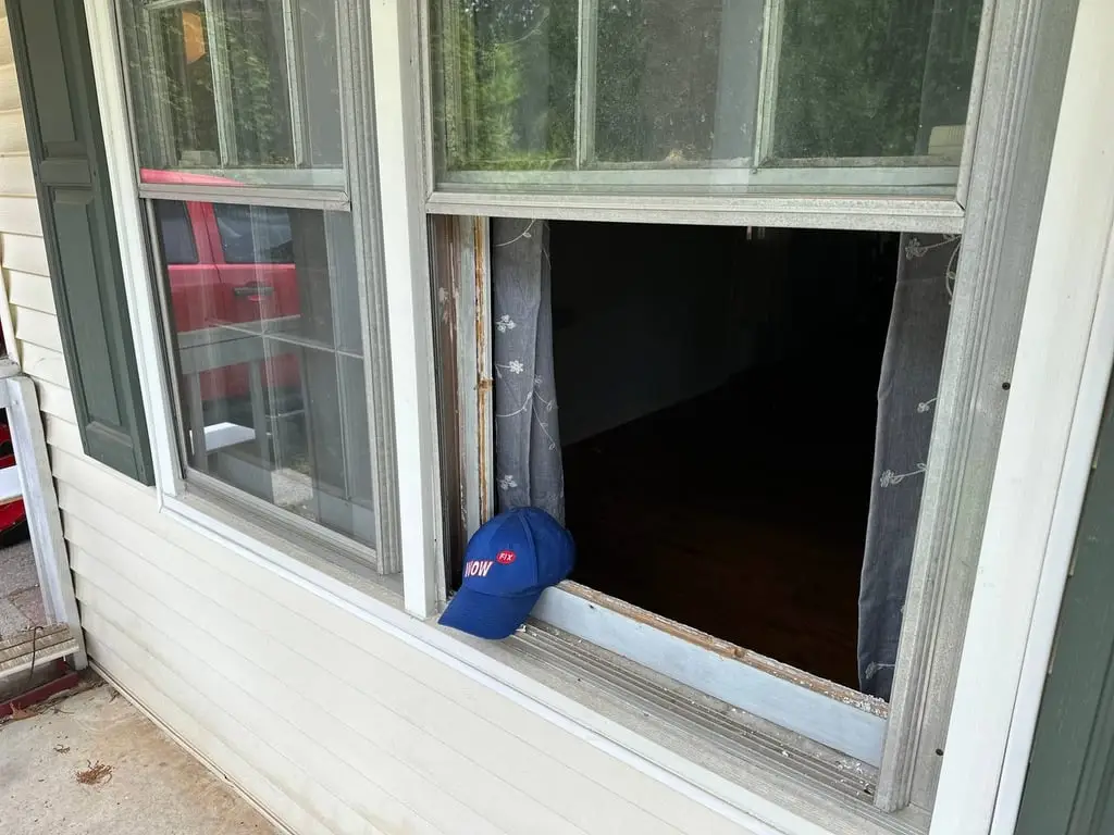 Double-hung window with a broken, missing lower glass pane before WowFix repair