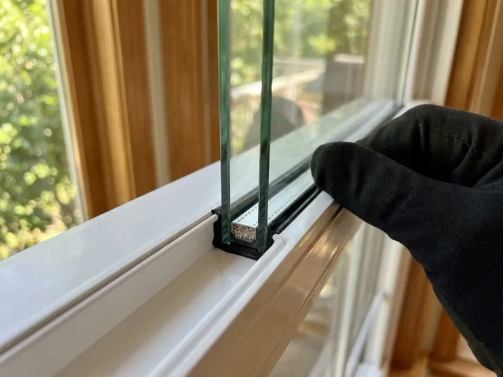 Made-to-measure double-pane insulated glass unit being fitted into an existing sash
