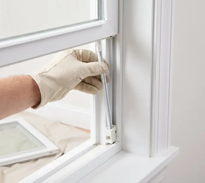 Illustration: a new channel balance going into the side jamb of a double-hung window, sash out