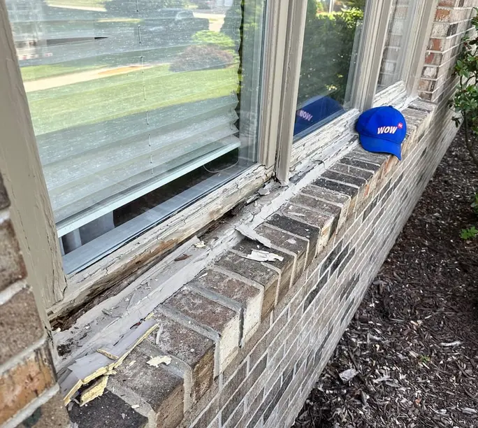 Rotted window sill with lifting paint on a Sandy Springs GA home shaded by mature hardwoods