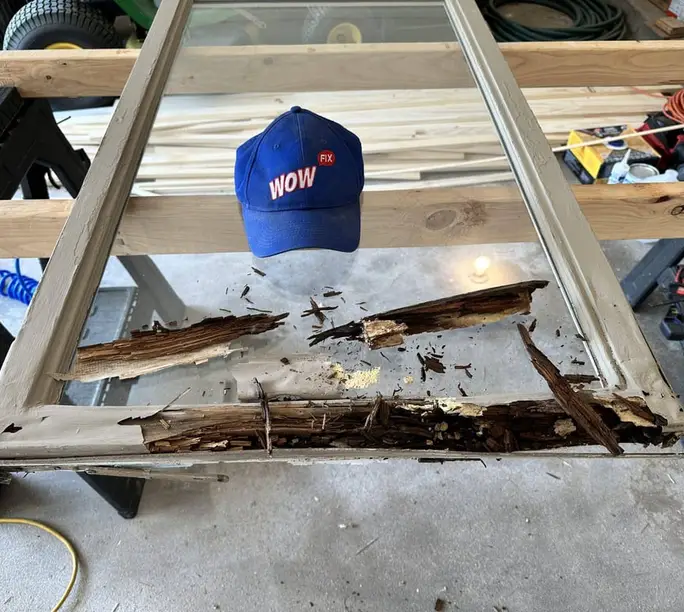 Rotted window wood cut out on sawhorses during a WowFix rebuild