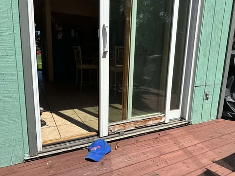 Sliding patio door with a rotted bottom rail mid-repair by WowFix — cap on the deck