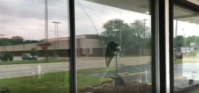 Damaged storefront glass pane before WowFix commercial replacement