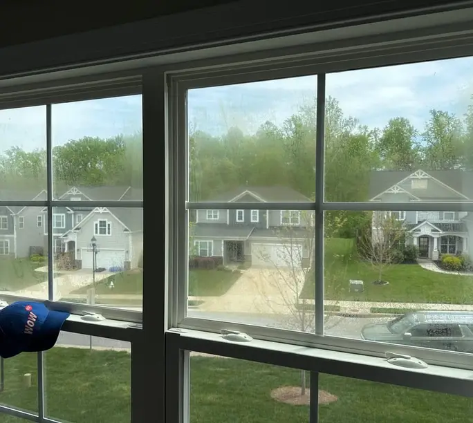 Builder-grade double-hung window inside a 2000s Houston-area subdivision home