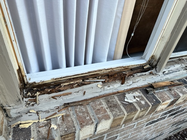 Image depicting a rotted wooden window sill in need of repair, showing visible signs of deterioration, such as chipped paint, darkened wood, and structural damage.