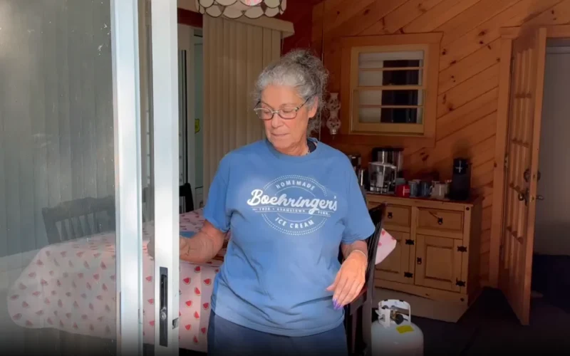 Home repair specialist inspecting sliding glass door in Charlotte home with wooden interior and kitchen background