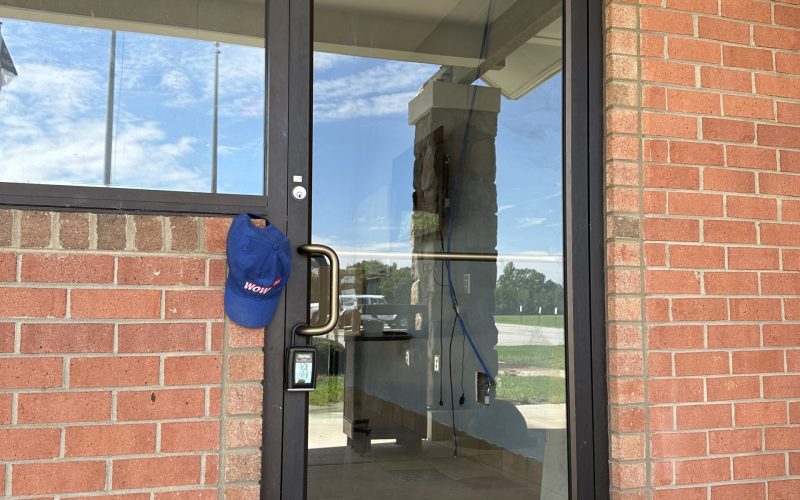 Commercial glass door entrance with WOW branded cap at brick building location in Greensboro Triad Metro area