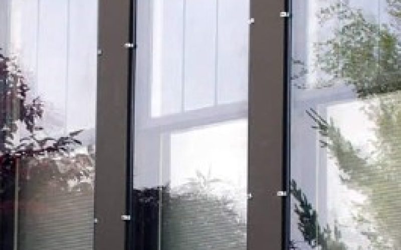 Triple panel brown-framed windows with white blinds installed on residential exterior, showing professional window craftsmanship