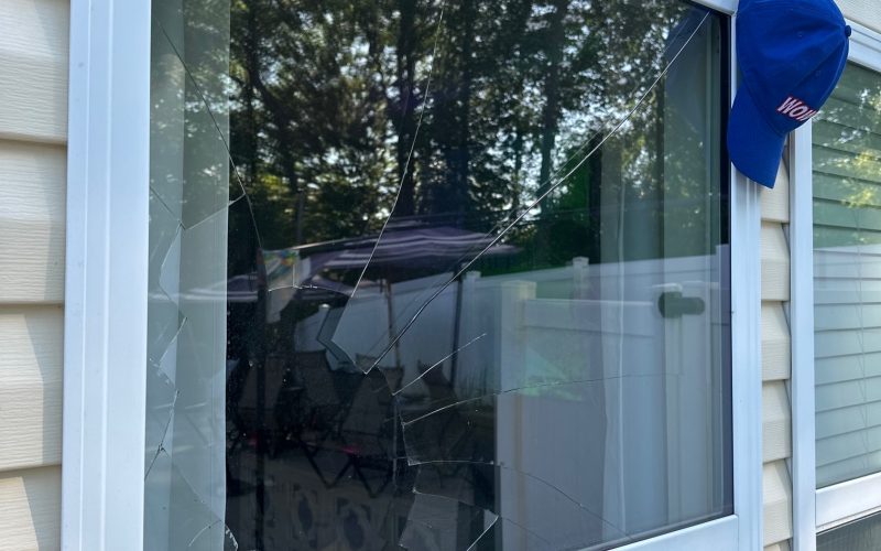 Broken residential window showing cracked glass pattern in white vinyl frame, demonstrating need for emergency window repair service