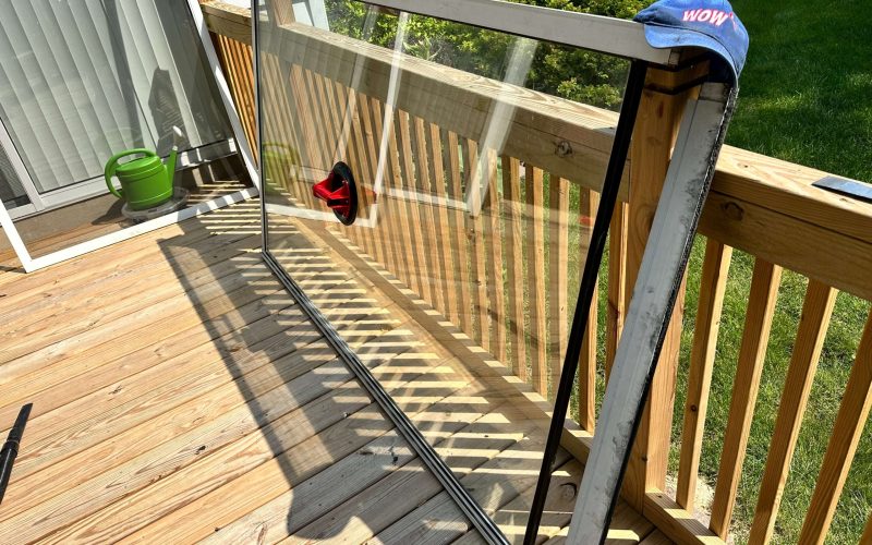 Professional window glass panel installation on wooden deck with WOW branding, showing quality craftsmanship and precision fitting