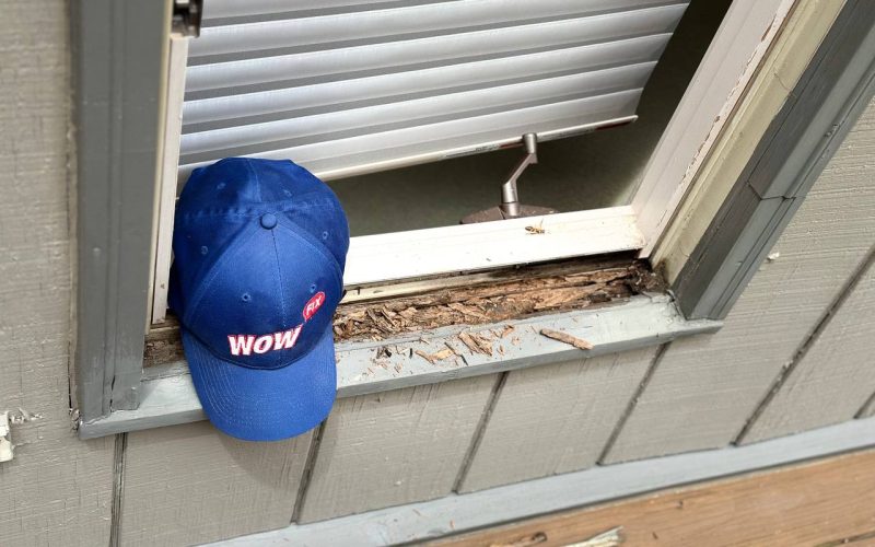 Deteriorating window frame with rotted wood and peeling paint, showcasing common window damage requiring professional repair