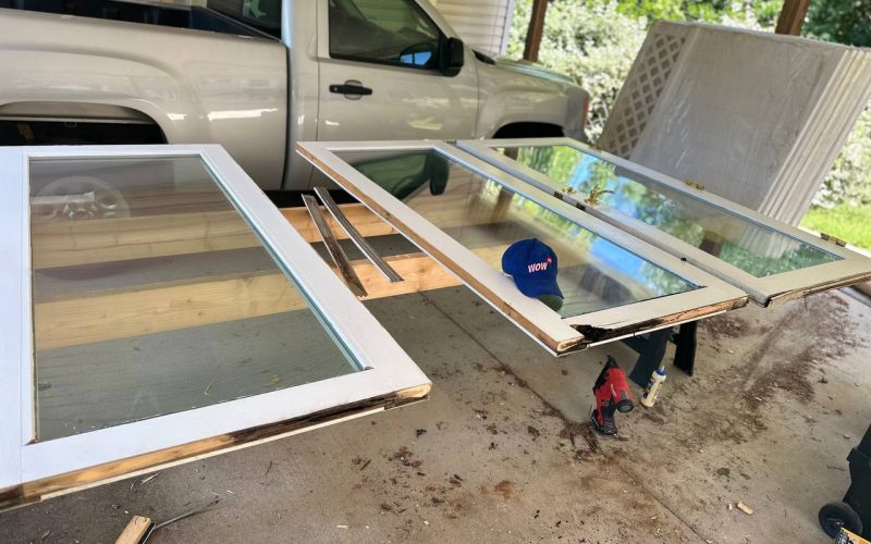 Window restoration in progress showing disassembled wooden window frames and glass panes with professional repair tools in North Carolina