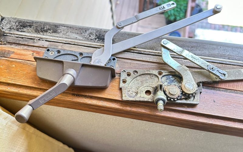 Window operator mechanism replacement showing old vs new Truth Entrygard hardware on wooden window frame in Charlotte home repair