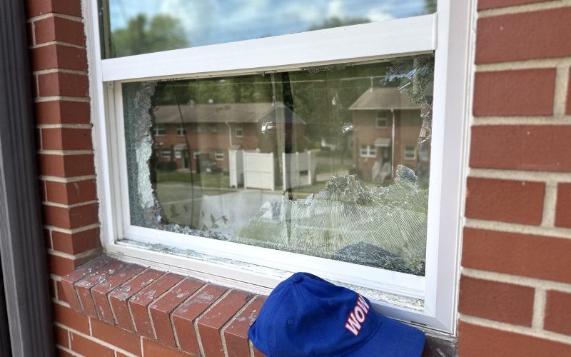 Broken residential window with shattered glass in white frame, showing damage requiring professional window repair in Raleigh
